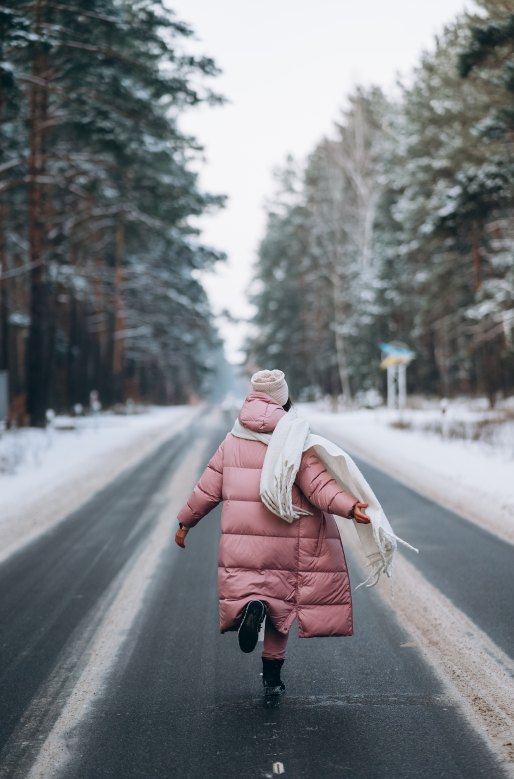 caucasian-woman-road-through-snowy-forest